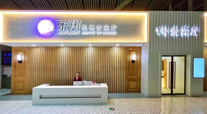 The entrance to the No. 1 VIP Lounge Landside at Zhangjiajie Hehua Airport features a reception desk and illuminated signage.