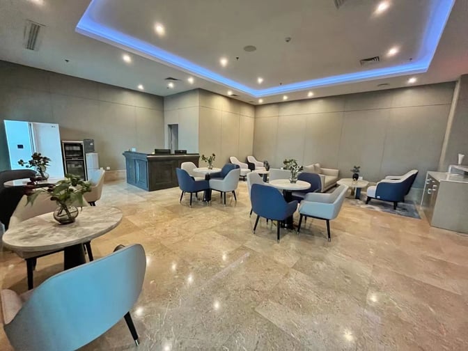 The No. 4 First Class Lounge at Zhangjiajie Hehua Airport features seating areas with tables and a reception desk.