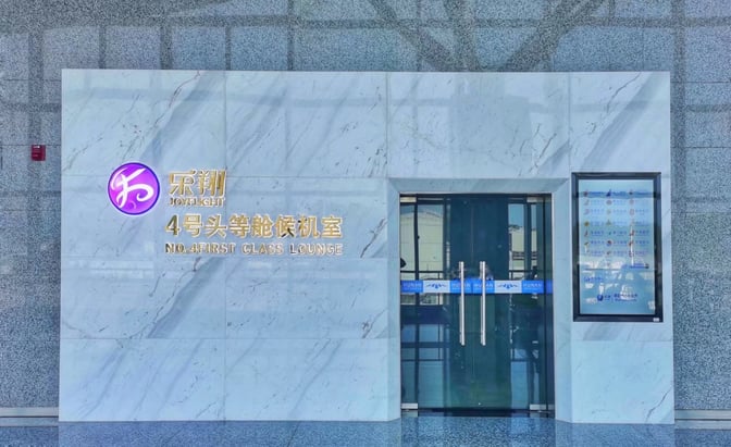 The entrance to No. 4 First Class Lounge at Zhangjiajie Hehua Airport features glass doors and signage indicating its location.