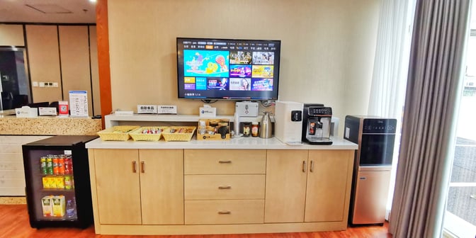 The snack station in No. 5 First Class Lounge at Zhangjiajie Hehua Airport offers beverages, snacks, and a coffee machine.