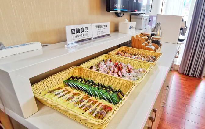 The self-serve snack station at Zhangjiajie Hehua Airport's No. 5 First Class Lounge offers a variety of packaged snacks.