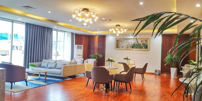 The seating area in the No. 5 First Class Lounge at Zhangjiajie Hehua Airport features comfortable chairs and sofas with tables for relaxation.