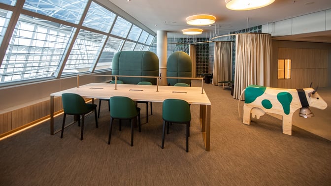 The marhaba Lounge at Zurich Airport features a communal work table with charging ports and semi-private seating areas.
