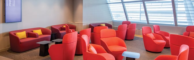 The marhaba Lounge at Zurich Airport features a seating area with armchairs and sofas, offering views of the tarmac through large windows.