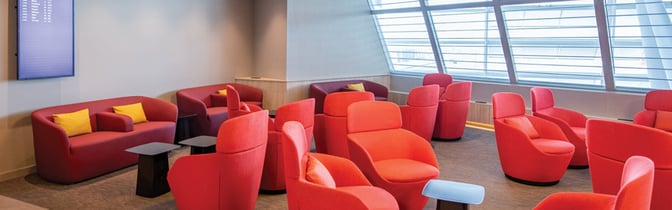 The marhaba Lounge at Zurich Airport features a seating area with armchairs and sofas, offering views of the tarmac through large windows.