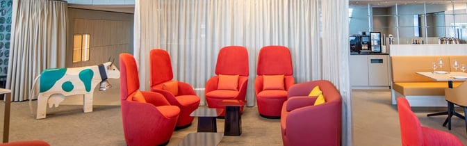 The marhaba Lounge at Zurich Airport features a seating area with high-back chairs and a nearby self-serve beverage station.