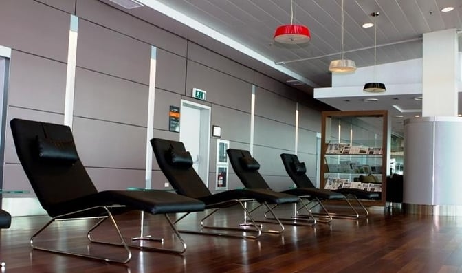 The Converse Bank Business Lounge at Zvartnots Airport features a seating area with reclining chairs and a magazine rack for travelers.